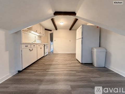 A kitchen with white cabinets and a grey floor.