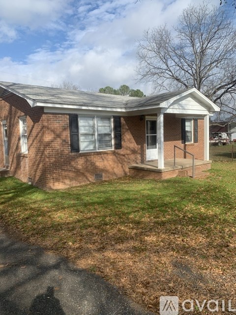A small brick house with a white door and a small porch.