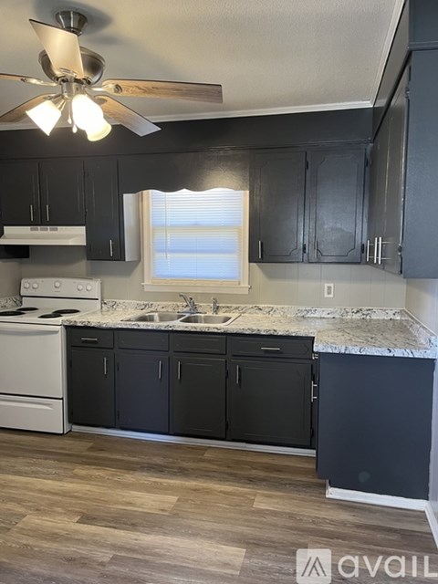 A kitchen with a white stove and black cabinets.