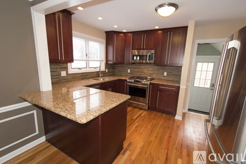 A kitchen with brown cabinets and a granite countertop.