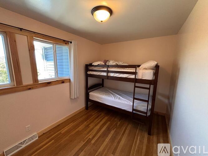 A bedroom with a bunk bed and a window.