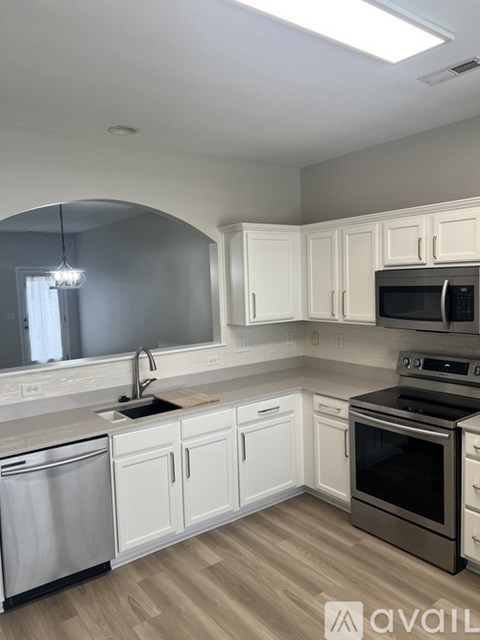 A kitchen with white cabinets and a stainless steel dishwasher.