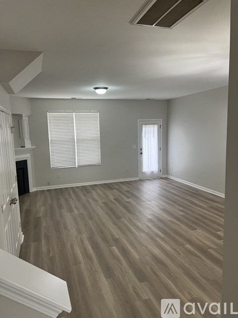 A room with wooden flooring and white walls.