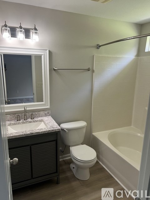 A bathroom with a toilet, sink, and bathtub.