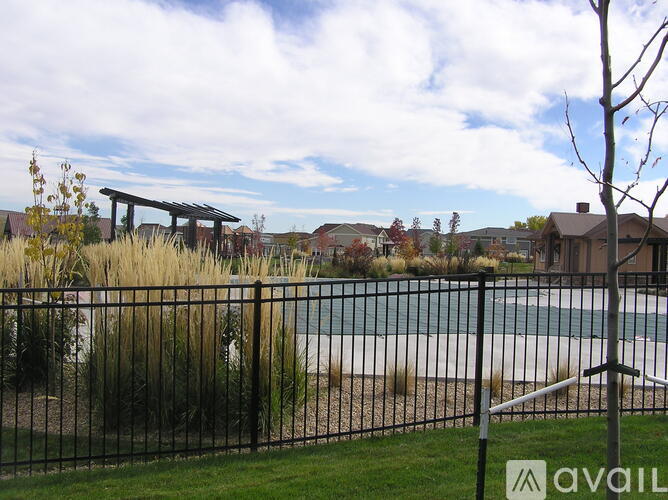 A pool surrounded by a fence with a sign that says "AVAIL" in the foreground.