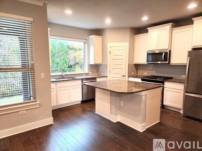 A kitchen with white cabinets and a granite countertop.