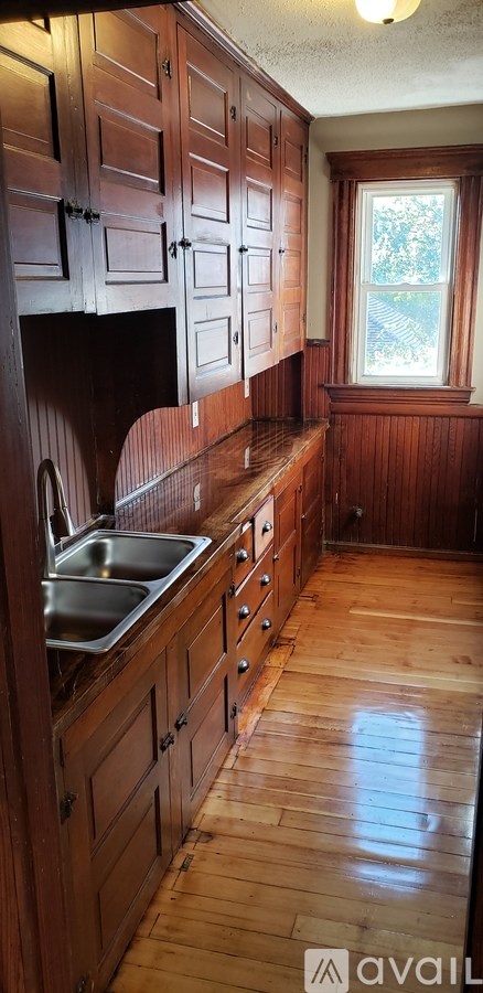 A kitchen with wooden cabinets and a window.