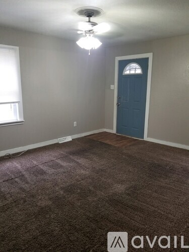 A room with a blue door and carpeted floor.