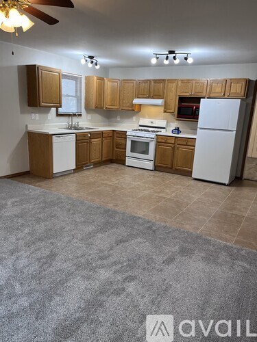 A kitchen with wooden cabinets and a white fridge.