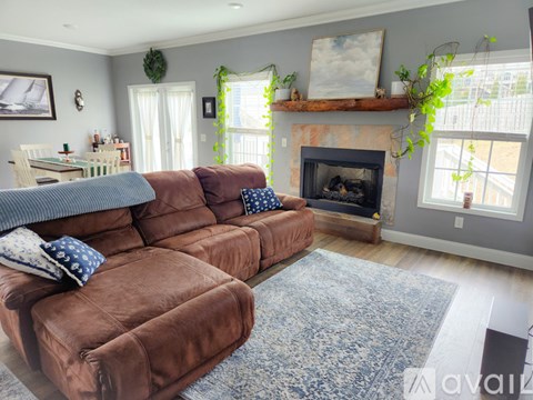 A living room with a brown couch and a fireplace.