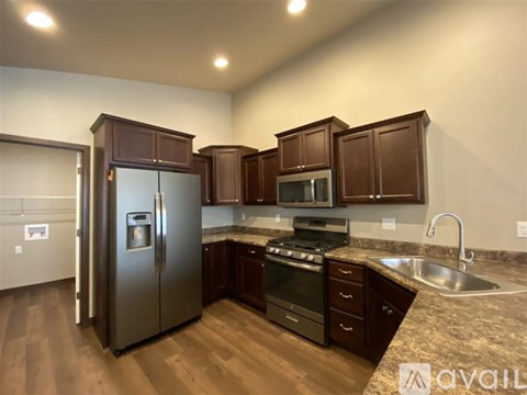 A kitchen with a refrigerator, oven, and sink.