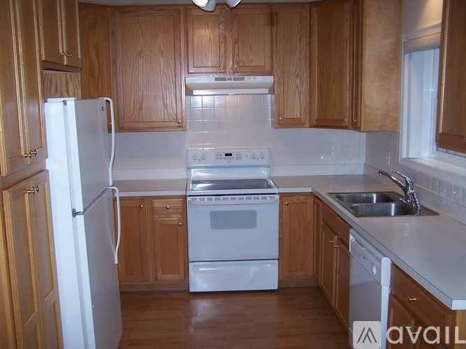 A kitchen with wooden cabinets and white appliances.