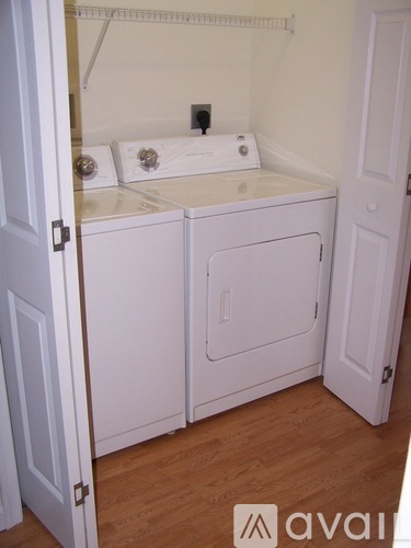 A small white laundry room with a washer and dryer.