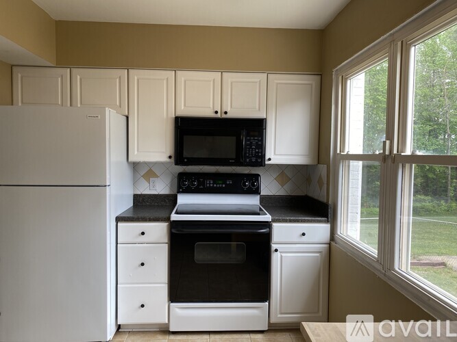 A kitchen with white appliances and cabinets.