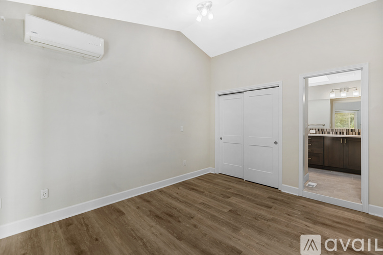 A room with a white door and a window with a view of a dining area.