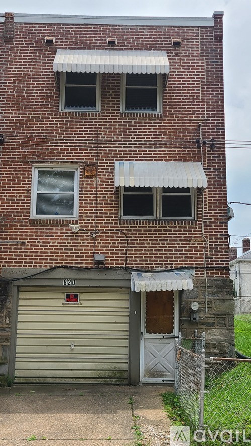 A red brick building with a closed grey garage door.