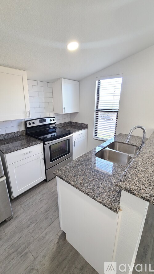 A kitchen with granite countertops and white cabinets.