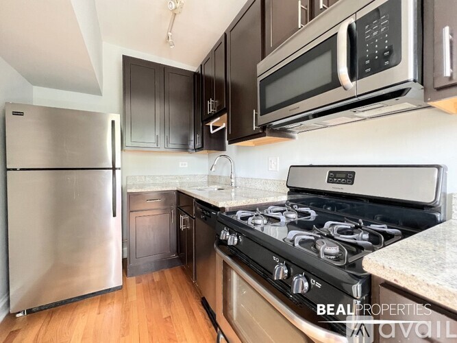 A kitchen with a stove, refrigerator, and microwave.