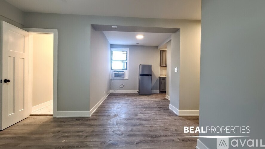 A BEALPROPERTIES sign is on a wall in an empty room.