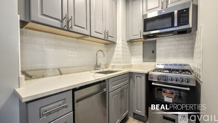 A kitchen with a white countertop and a stove top oven.
