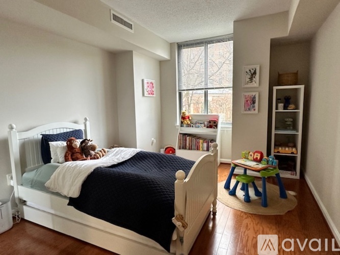 A bedroom with a white bed and a blue blanket.