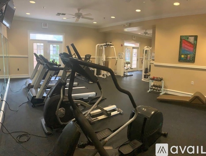 A gym with treadmills, elliptical machines, and other exercise equipment.