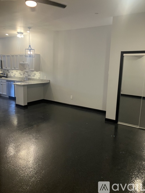 A room with a ceiling fan and a counter with a backsplash.