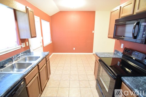 A kitchen with a black oven and a black microwave.