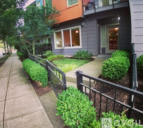 A black metal fence runs along a sidewalk.