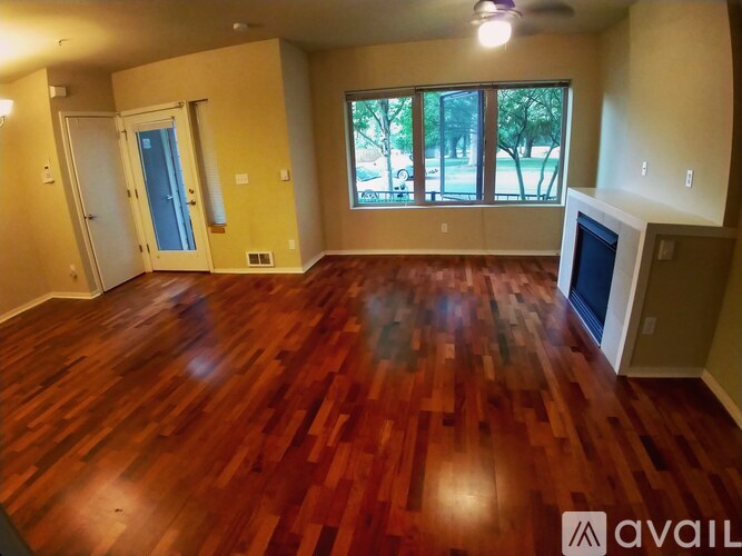 A room with wooden flooring and a television on the wall.