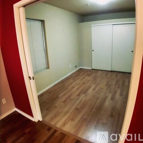 A room with a wooden floor and a red wall.