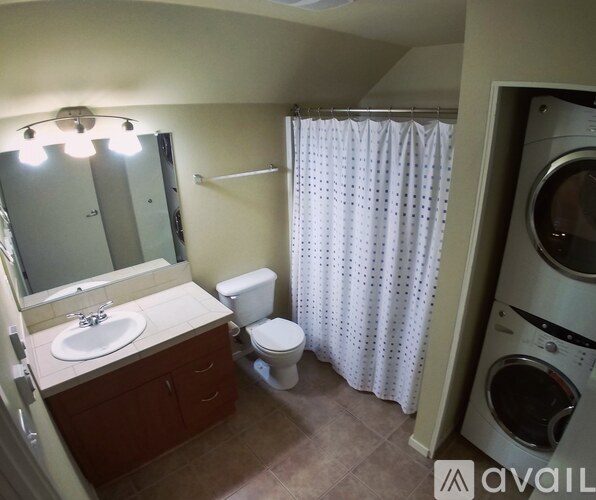 A small bathroom with a toilet, sink, and washing machine.
