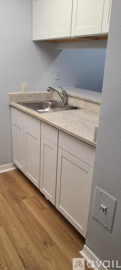 A kitchen with white cabinets and a granite countertop.