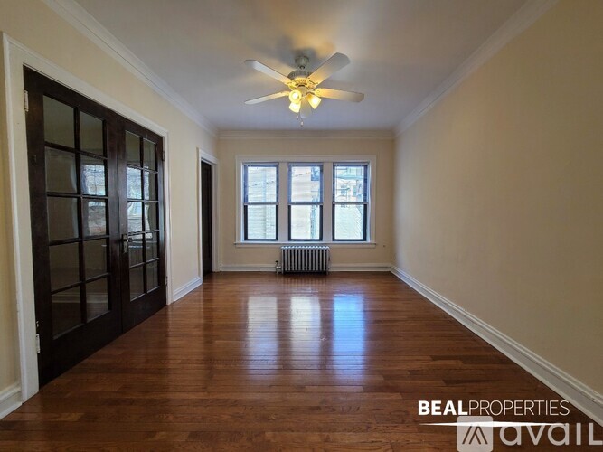 A room with a ceiling fan and wooden floors.