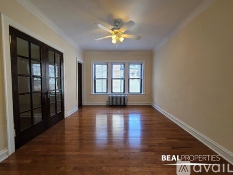 A room with a ceiling fan and wooden floors.