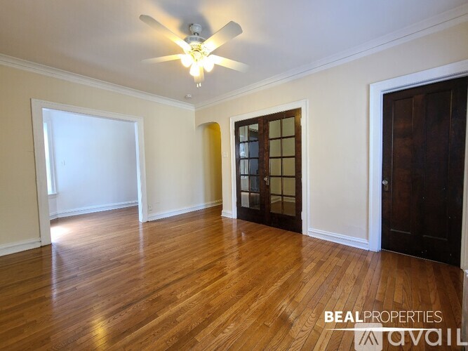 A room with wooden floors and a ceiling fan.