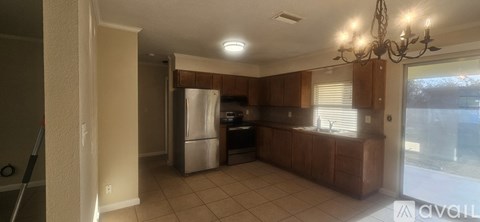 A kitchen with wooden cabinets and a silver refrigerator.