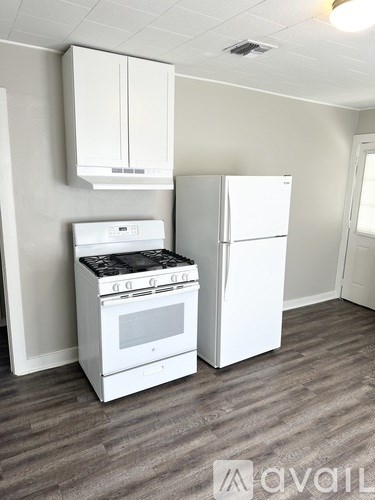 A white stove and refrigerator in a room with a grey floor.