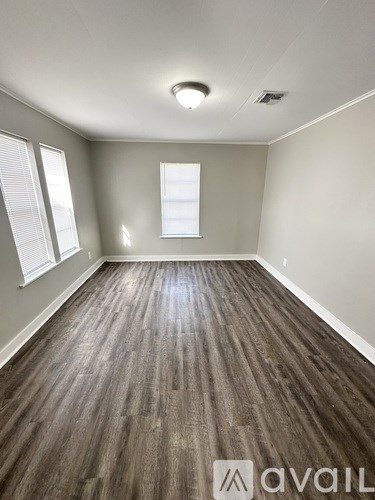 A room with wooden flooring and a window.