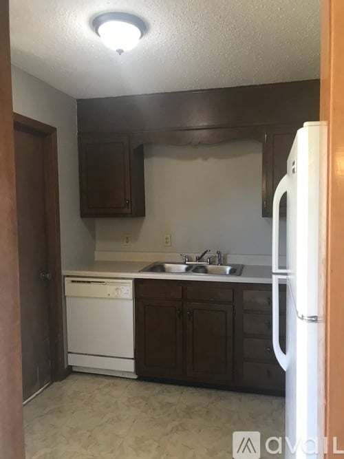 A kitchen with a white fridge and a white dishwasher.