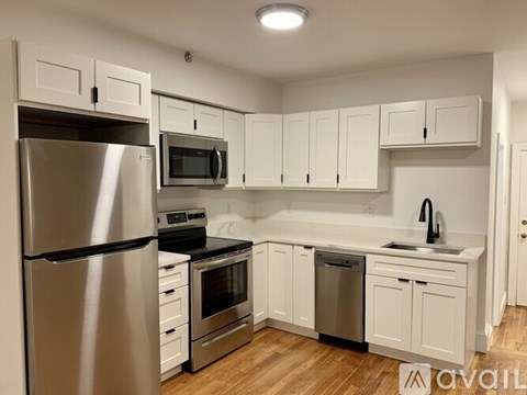 A kitchen with white cabinets and stainless steel appliances.