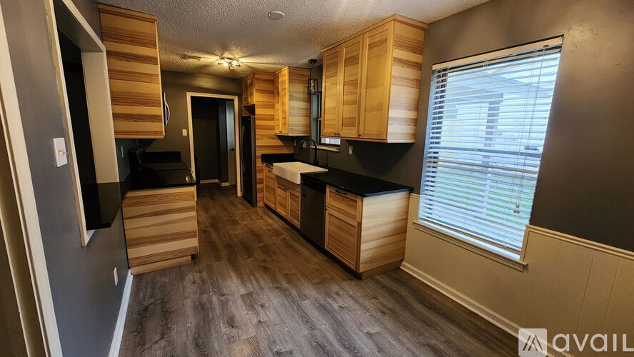A kitchen with wooden cabinets and a black countertop.
