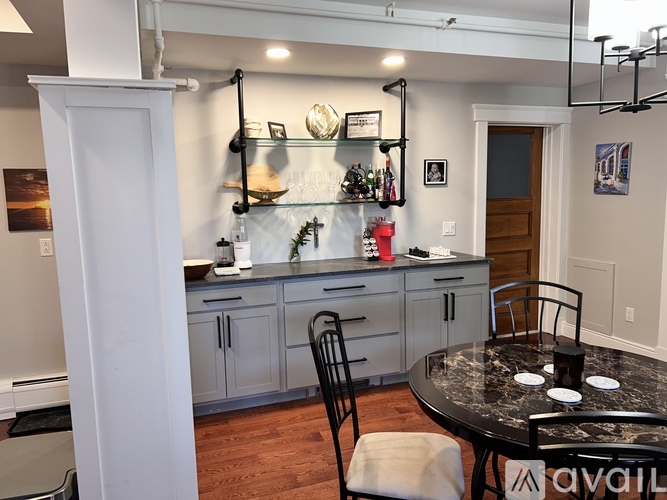 A kitchen with a table and chairs in front of it.