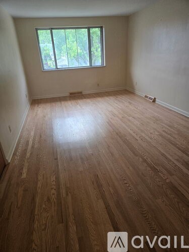 A room with wooden flooring and a window.