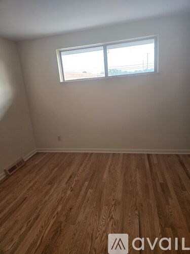 A room with wooden flooring and a window.