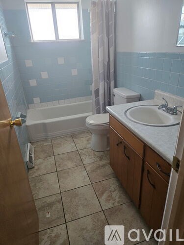 A bathroom with a toilet, sink, and bathtub.
