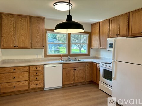 A kitchen with wooden cabinets and white appliances.