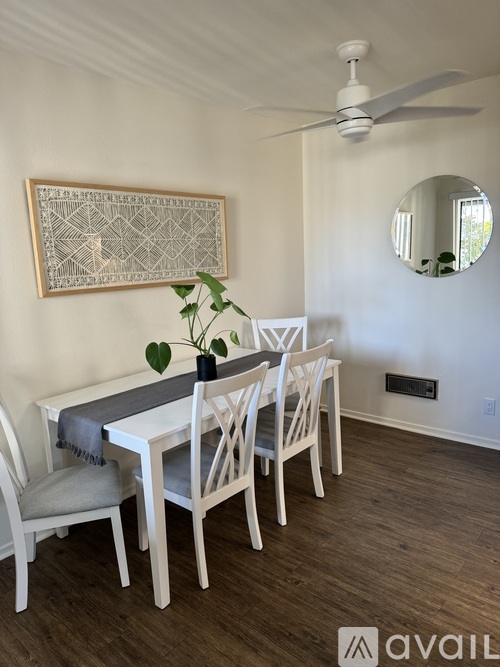 A dining room with a white table and chairs.