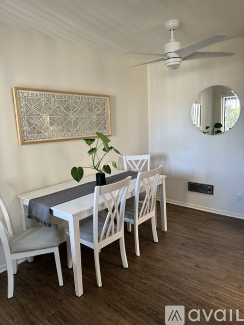 A dining room with a white table and chairs.