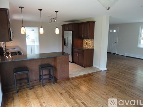 A kitchen with wooden floors and a bar area.